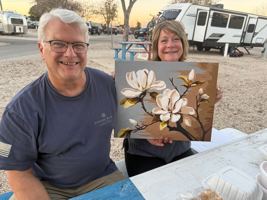 A customer displaying their completed paint-by-number artwork