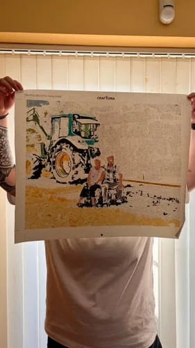 Customer holding an in-progress custom paint-by-numbers canvas of a tractor and family